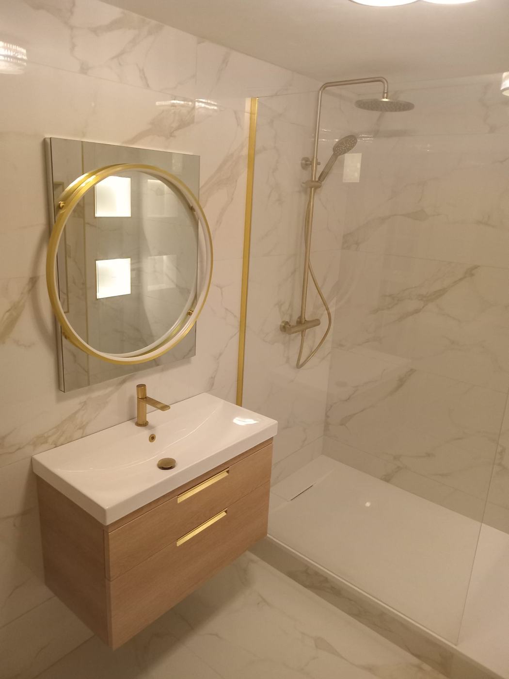 White and gold marble bathroom with brass shower and oak vanity