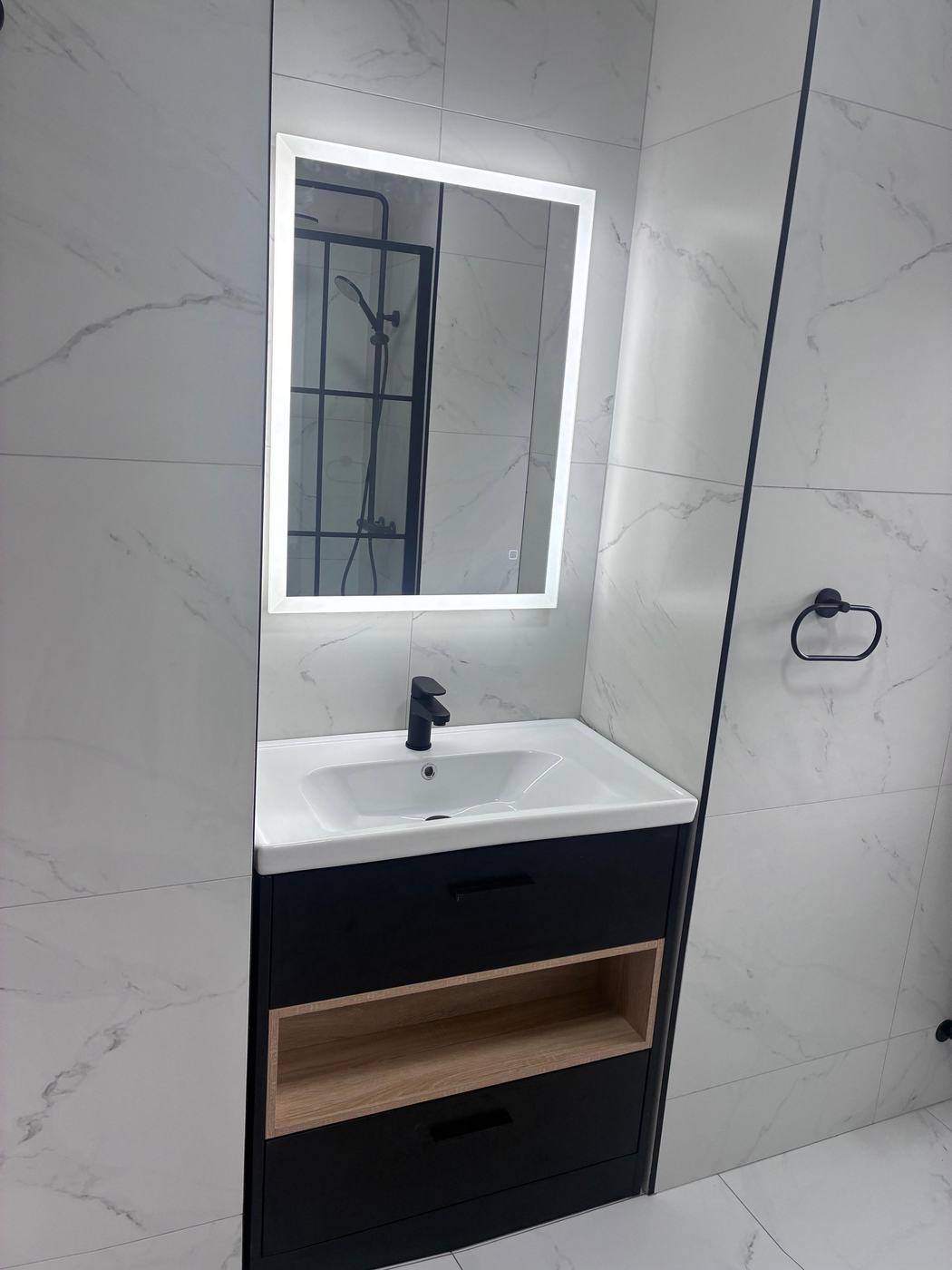 White marble vanity with matt black tap and LED mirror