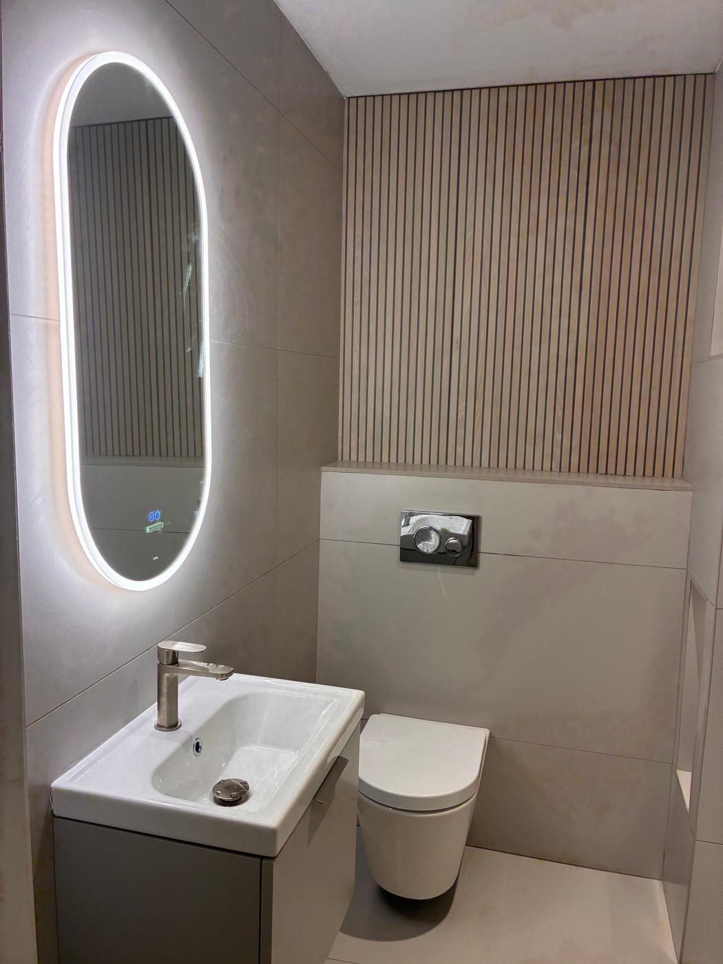 Cloakroom with oak slat wall and oval LED mirror